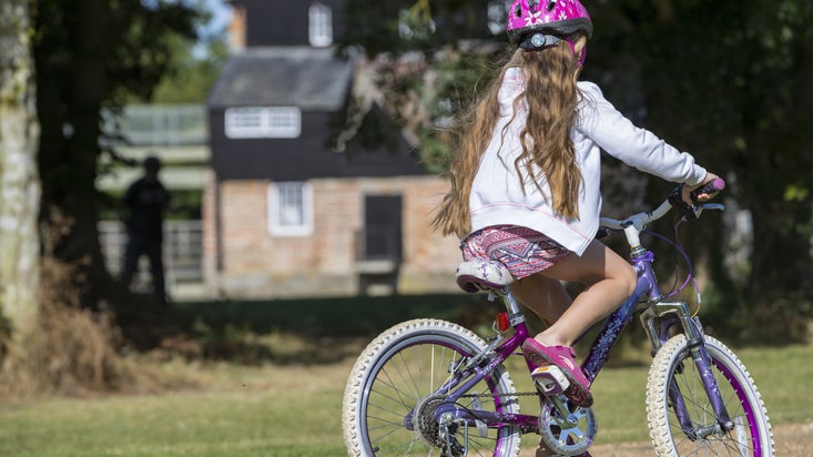 Child on a bike at Houghton Mill and Waterclose Meadows